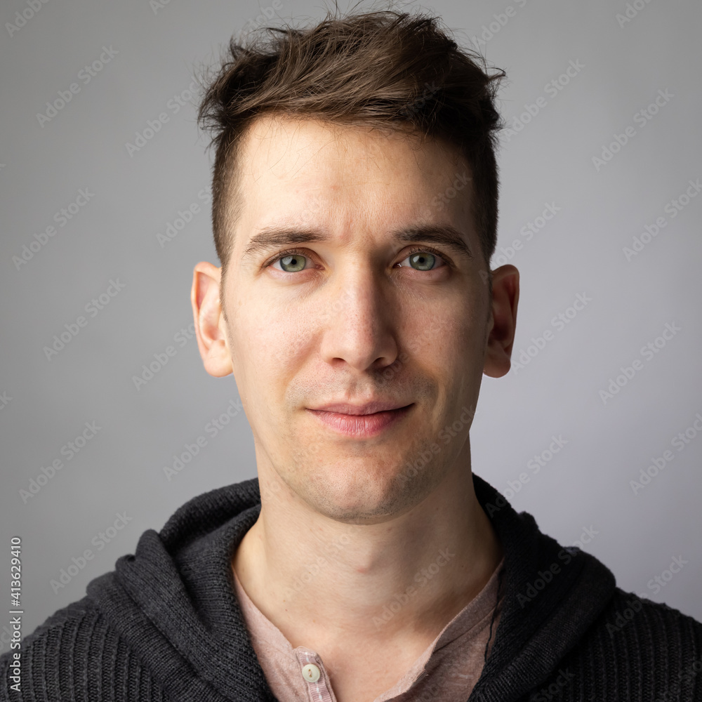 Fototapeta premium Stylish man in late 20s looks towards camera with a calm happy look 