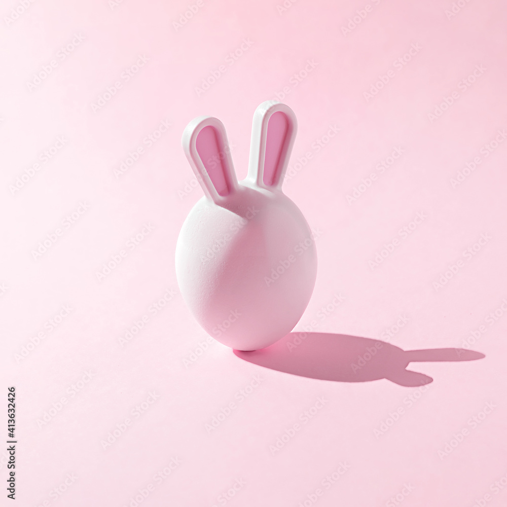 Easter egg with bunny ears on a pink background. A creative Easter concept. Easter egg with bunny ears on a pink background. A creative Easter concept.