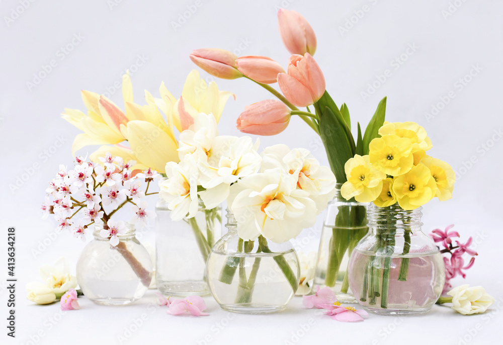 Spring blossoming daffodils, tulips and flowers light bright background, pastel and soft springtime floral card Spring blossoming daffodils, tulips and flowers light bright background, pastel and soft springtime floral card