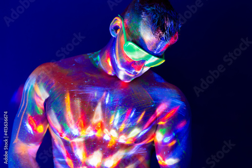 Schilderij op canvas .Portrait of a pumped-up man at a disco. Fluorescent paint on face in with UV li