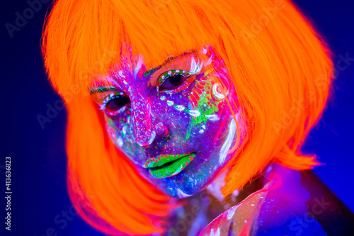 Fototapeta Naklejka Na Ścianę i Meble -  Portrait of woman in with neon makeup. Fluorescent paint in ultraviolet light