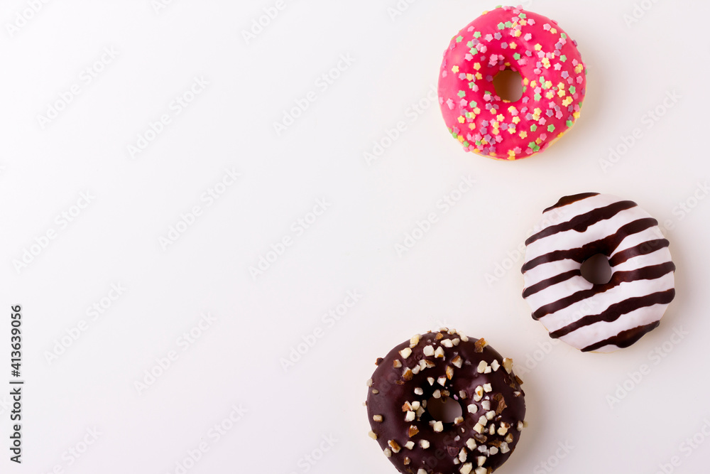 Yummy glazed assorted doughnuts on white background on the right side. Top view. Copy space Yummy glazed assorted doughnuts on white background on the right side. Top view. Copy space