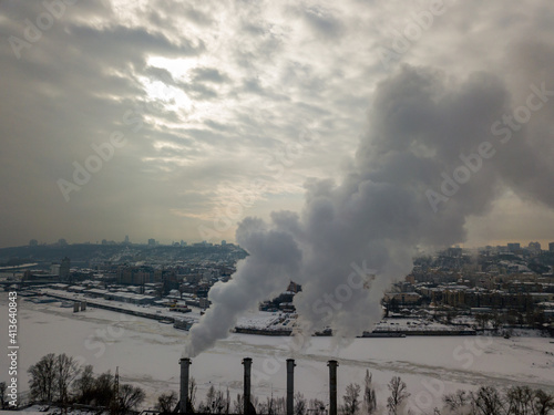 Fuming chimneys of a power plant. Aerial drone view. Winter snowy evening.
