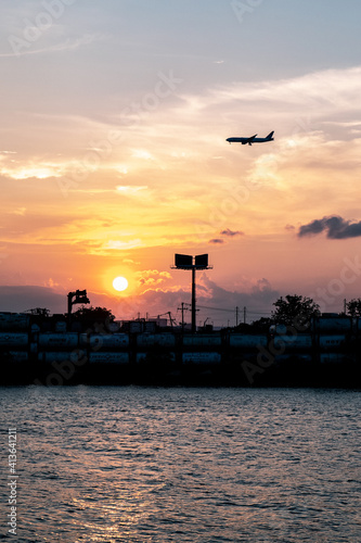 Orange Sunset Portrait with Silhouetted Airplane in Sky © Mark