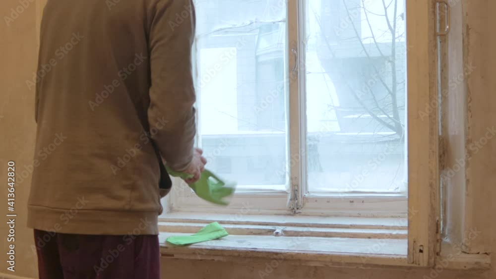 man worker clean window wooden frames in gloves and mask man worker clean window wooden frames in gloves and mask