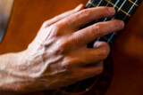 man hands playing acoustic guitar