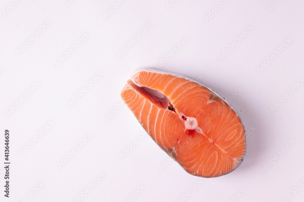 A piece of salmon on a white background. Horizontal orientation. View from above. A piece of salmon on a white background. Horizontal orientation. View from above.