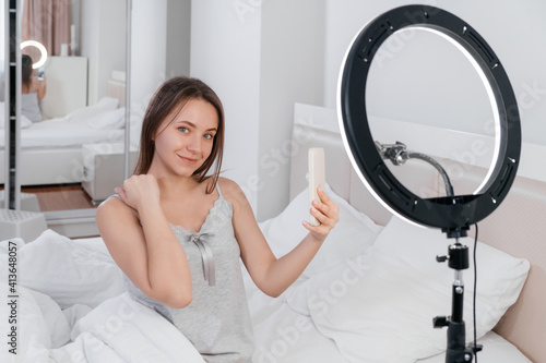 Female Blogger Recording Vlog Video on smartphone At Home Online Influencer On near bed. Streaming beauty bloger