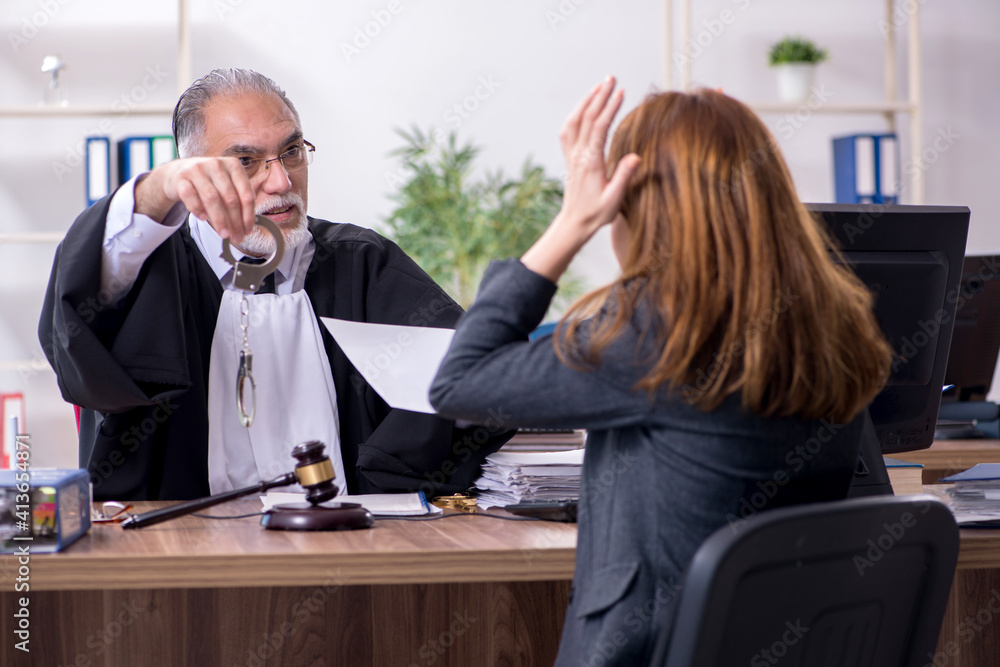 Old male judge and female client in the office Old male judge and female client in the office