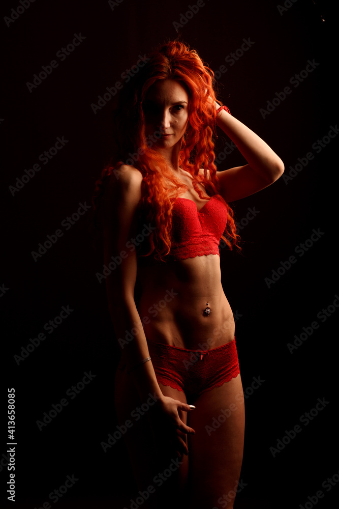 Fototapeta premium Beautiful young woman with long hair in lingerie on black background looking at camera