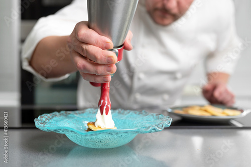 Professional chef holding a foam siphon in a restaurant kitchen. High quality photo photo