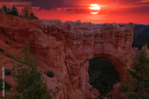 A natural bridge enjoys a beautiful orange sunset in Bryce Canyon National Park in Utah, USA. 