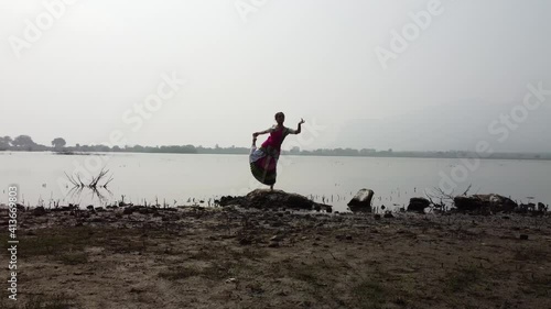 A bharatnatyam dancer displaying a classical bharatnatyam pose in the nature of  Vadatalav lake, Pavagadh. Beautiful indian girl dancer in the posture of Indian classical dance bharatanatyam . photo