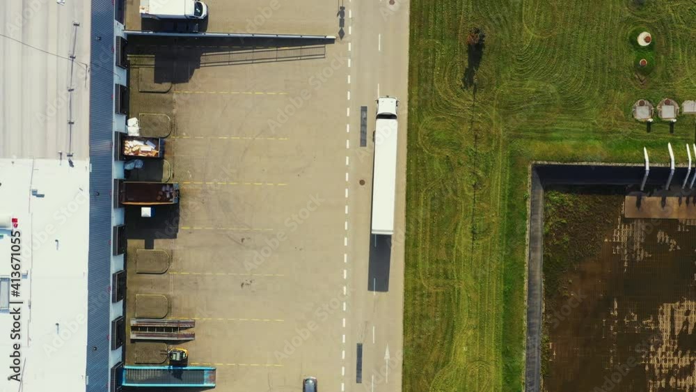 Logistics park with a warehouse - loading hub. Semi-trucks with freight trailers standing at the ramps for loading unloading goods. Aerial Logistics park with a warehouse - loading hub. Semi-trucks with freight trailers standing at the ramps for loading unloading goods. Aerial