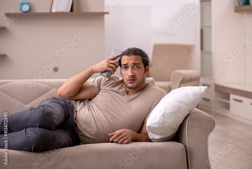Young man lying on the sofa at home