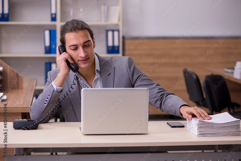 Young male employee working in the office Young male employee working in the office