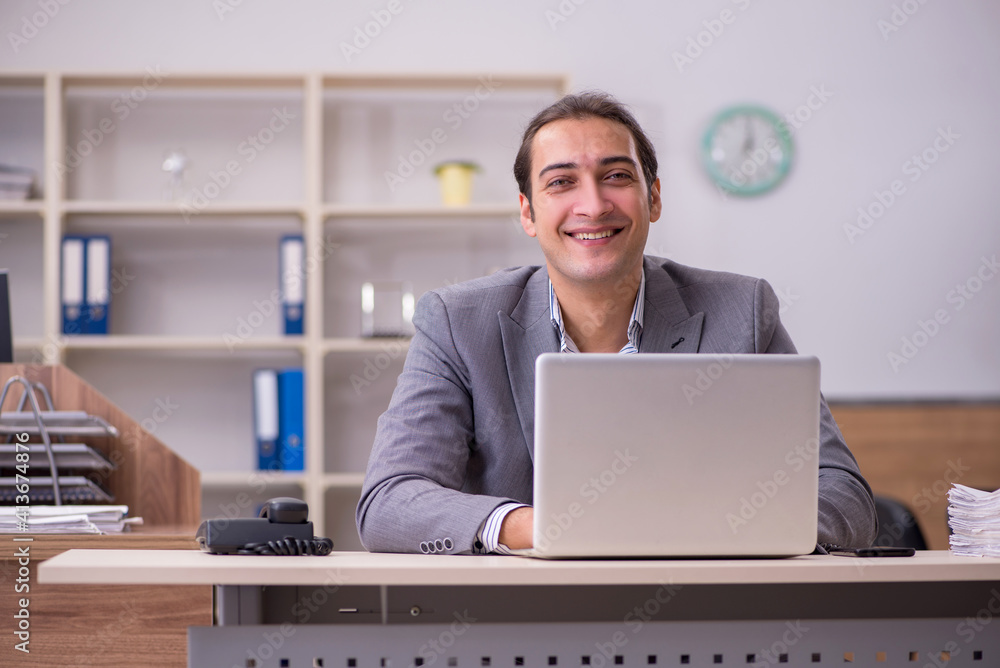 Young male employee working in the office Young male employee working in the office