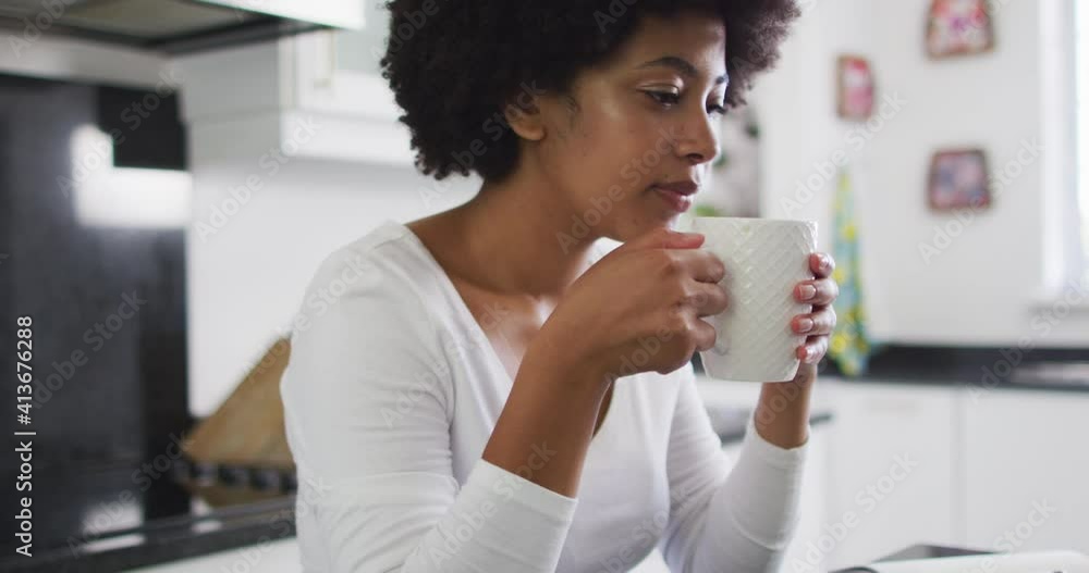 African american woman drinking coffee in the kitchen at home African american woman drinking coffee in the kitchen at home