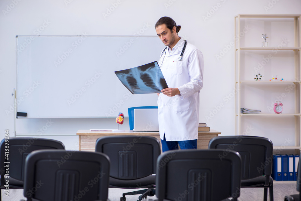 Young male doctor radiologist giving seminar in the classroom Young male doctor radiologist giving seminar in the classroom