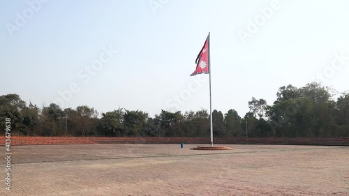 National Flag of Nepal on a tall flagpost against wind photo