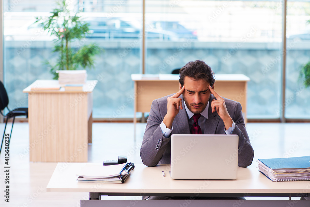 Young male employee working in the office Young male employee working in the office