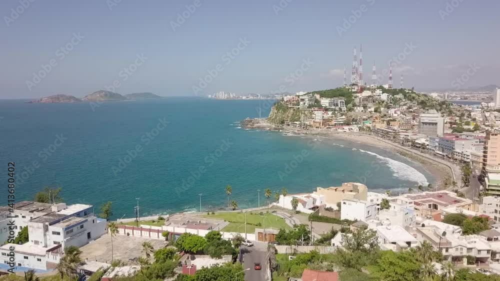 Aerial drone dolly shot above coast shore city Mazatlan, Sinaloa, Mexico with sea ocean view. Flying along the beach seashore in latin america with houses and hotels. Aerial drone dolly shot above coast shore city Mazatlan, Sinaloa, Mexico with sea ocean view. Flying along the beach seashore in latin america with houses and hotels.
