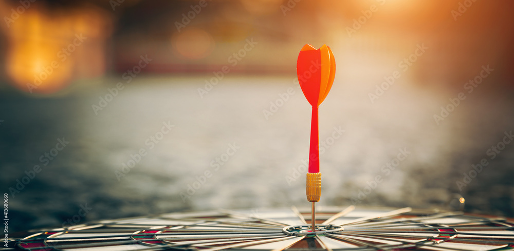 bullseye target or dart board has red dart arrow throw hitting the center of a shooting for business targeting and winning goals business concepts. bullseye target or dart board has red dart arrow throw hitting the center of a shooting for business targeting and winning goals business concepts.