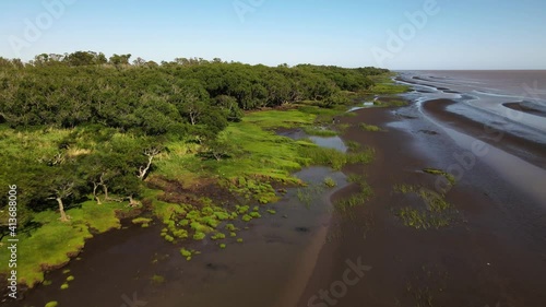 Rising aerial of woodlands and sandbanks by edge of Rio de La Plata photo