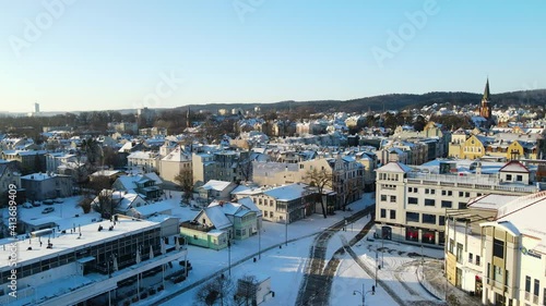 Deserted due to Covid downtown of Sopot with tracks cleared from the white snow on a sunny bright day. Drone panning shot photo