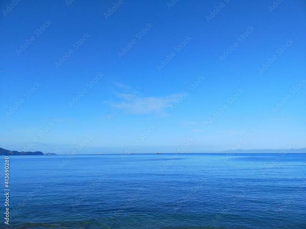 晴れた夏の日の青空と穏やかな海と水平線の風景