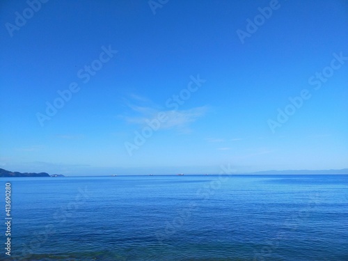 晴れた夏の日の青空と穏やかな海と水平線の風景 © たあきん