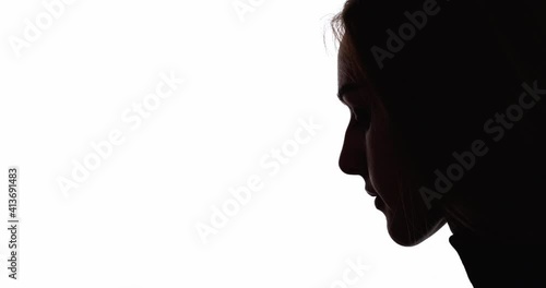 Woman silhouette. Female rights. Gender discrimination. Disappointment loneliness. Dark contrast profile face outline of hopeless insecure lady looking down isolated on white copy space background. photo