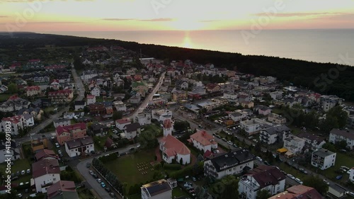 City of seaside village Karwia, Poland with sunset in the background. Amazing view of buildings in the sunrise near the sea. Sunset over the city. Aerial view of city at dusk.  photo