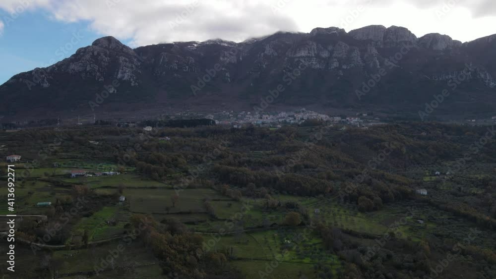 Suggestive Italian landscape with olive-groves on the ground and mountings in the back shot in a single aerial drone 4k video on a sunny day. Suggestive Italian landscape with olive-groves on the ground and mountings in the back shot in a single aerial drone 4k video on a sunny day.