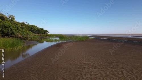 Low forward aerial of sand banks and reeds by bank of Rio de la Plata photo