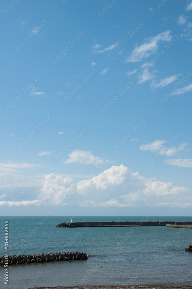 防波堤のある静かな青い海と青空
