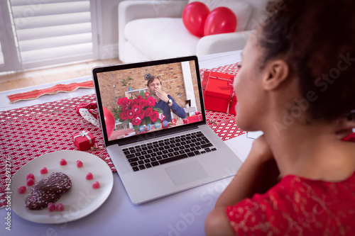 Diverse couple making valentine's date video call the man on laptop screen blowing kiss