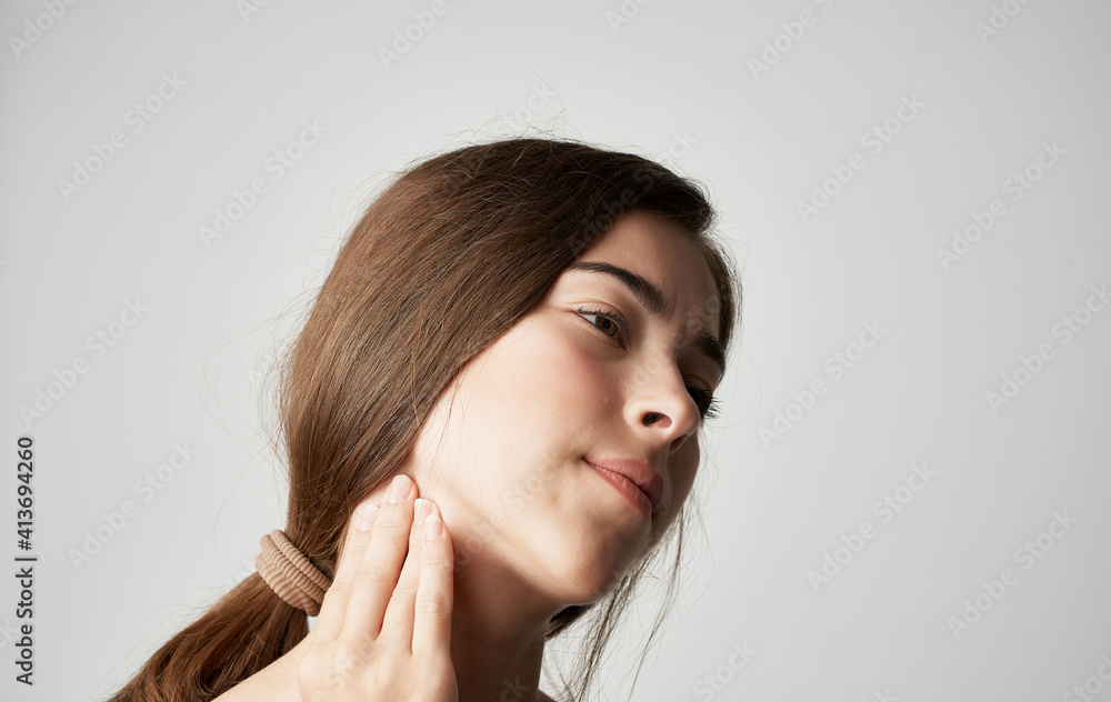 woman in gray t-shirt health problems holds hand near face pain discomfort woman in gray t-shirt health problems holds hand near face pain discomfort
