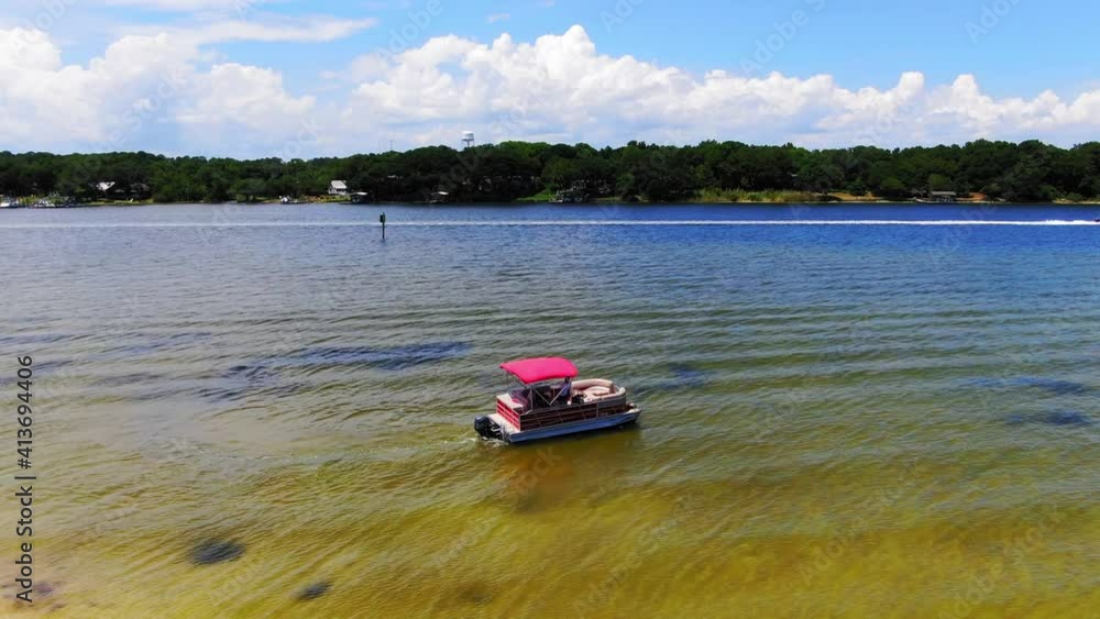 Aerial view of a pontoon boat leaving some small islands near Destin Florida. Aerial view of a pontoon boat leaving some small islands near Destin Florida.