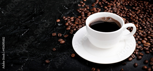 Cup of black coffee with coffee beans near at black background. Copy space for your text