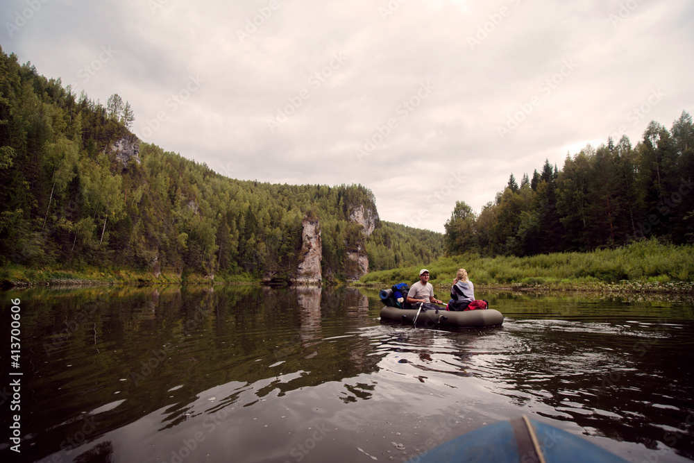 Young friends river rafting against cloudy sky Young friends river rafting against cloudy sky