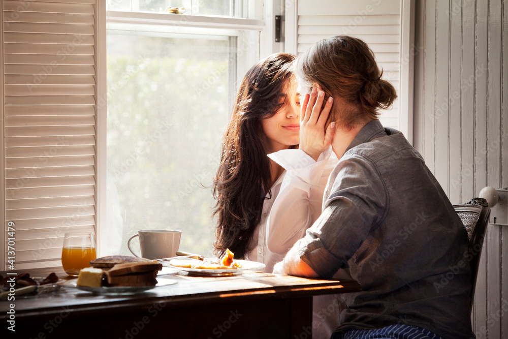 Affectionate couple by breakfast table at home Affectionate couple by breakfast table at home