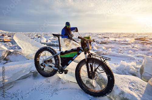 Man with bicycle on the frozen lake.