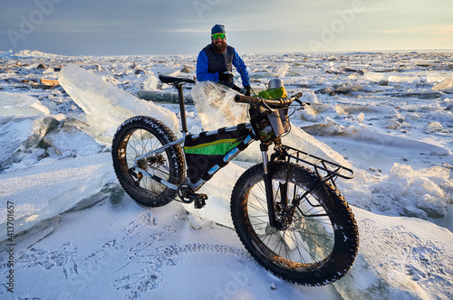 Man with bicycle on the frozen lake.