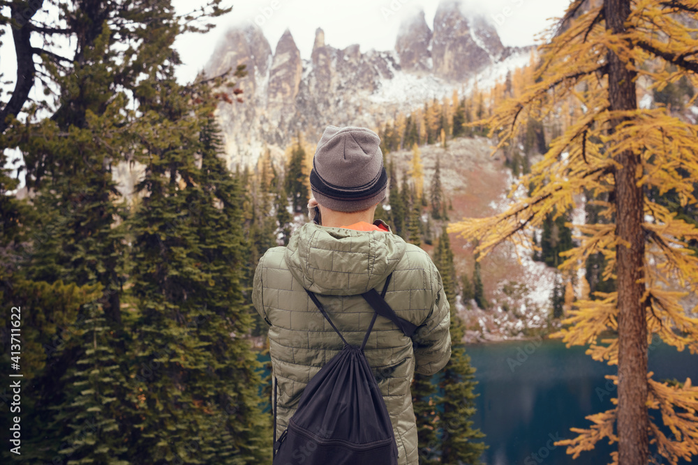 Rear view of man standing in forest and looking at view Rear view of man standing in forest and looking at view