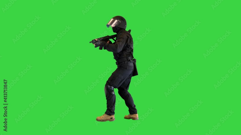 Police unit in black tactical suit searching for a target on a Green Screen, Chroma Key. Police unit in black tactical suit searching for a target on a Green Screen, Chroma Key.