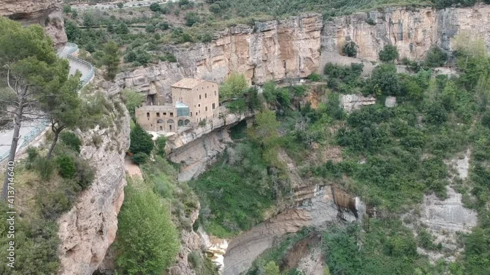 Aerial views of a waterfall with a cave and an old building in Catalonia, Spain Aerial views of a waterfall with a cave and an old building in Catalonia, Spain