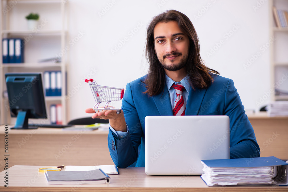 Young male employee in ecommerce concept in the office Young male employee in ecommerce concept in the office