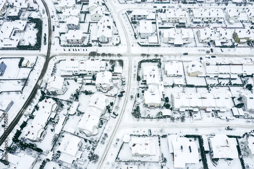 traditional housing estate in the suburbs in snowy winter day. aerial photo from flying drone