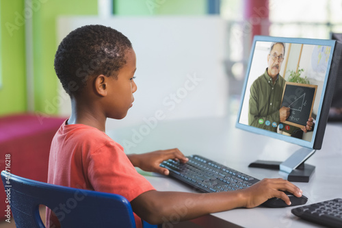 Male african american student having a video call with male teacher on computer at school
